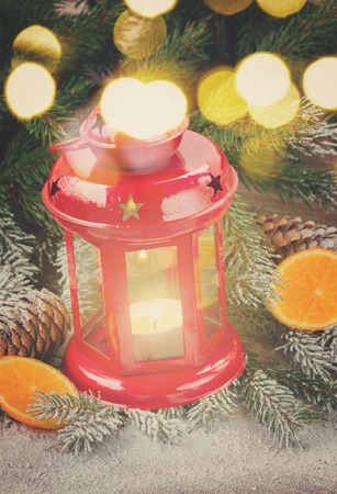 christmas red lantern close up with evergreen tree and snow, retro tonedの写真素材