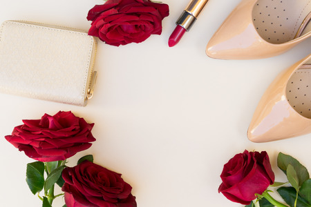 Nude colored high heels with lipstick, red roses and wallet hero headerの写真素材