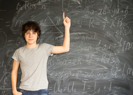 Teenager boy getting an idea with math formulas - back to school education conceptの写真素材