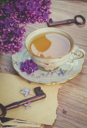 summer cup of tea with lilac flowers and vintage photos, retro tonedの写真素材