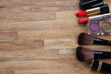 Set of black brushes and lipsticks on wooden tableの写真素材