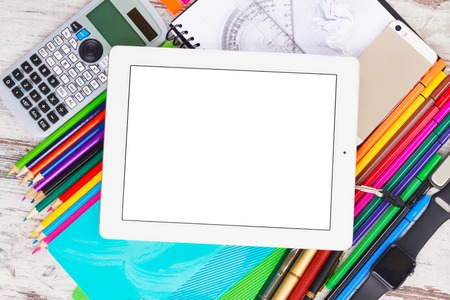 back to school frame with school supplies and electronic device tablet with empty screen on wooden tableの写真素材
