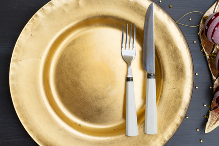 Christmas empty golden plate with knife and forkの写真素材
