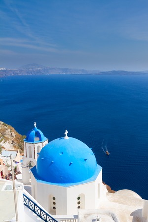 traditional blue dome of church with bellfry against blue sea, Oia, Santoriniの写真素材