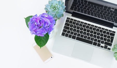 Laptop and phone on white table mock up flat lay scene, copy space on white tableの写真素材