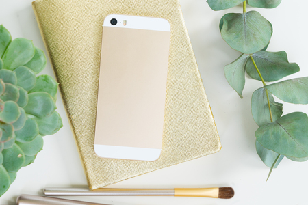 Back of the phone with golden woman accessories mock up flat lay styled scene, top view, copy space on empty screen backgroundの写真素材