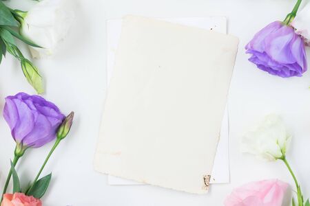 Pink, white and violet eustoma flowers and blank aged paper notesの写真素材