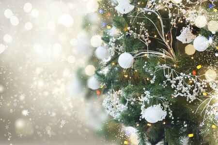 christmas tree with holiday white decorations and lights on silver background with copy spaceの写真素材