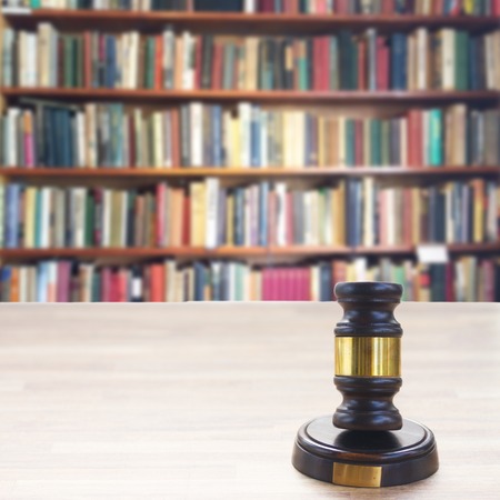 Wooden Law Gavel with a row of law books in library
