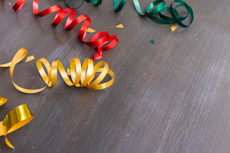 Carnaval festive curling paper decorations with copy space on dark woodの写真素材