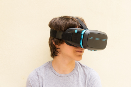 Teenager wearing VR virtual realty glasses close up