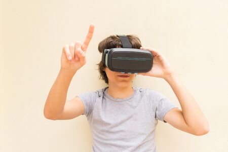 Teenager wearing and touching something in VR virtual realty glassesの写真素材