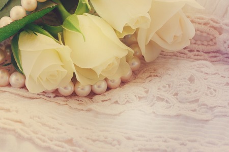 white fresh roses with lace and pearls jewelery, retro tonedの写真素材