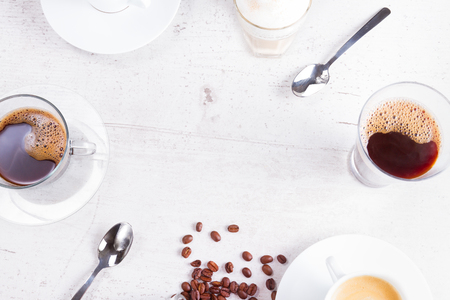 coffee break concept - lots of coffee cups with copy space on white wooden tableの写真素材