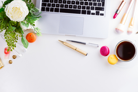 Feminine workspace border with notebbok keyboard, coffee and flowers, top view and copy spaceの写真素材