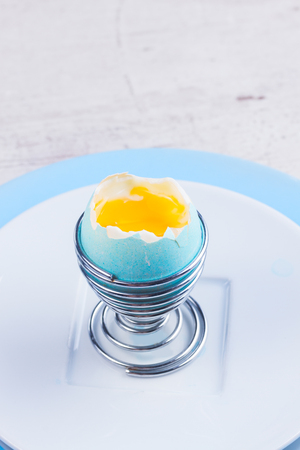 One blue easter egg with yellow yolk - easter breakfast conceptの写真素材