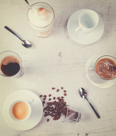 coffee break concept - frame of lots of coffee cups with copy space on white wooden table, retro tonedの写真素材
