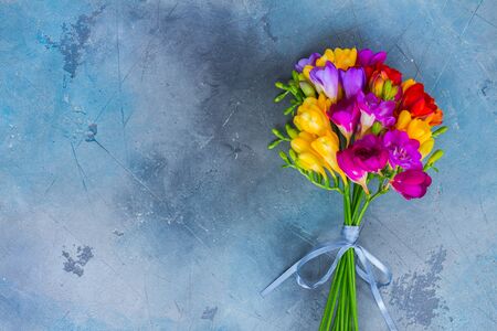 Posy of fresh freesia flowers on gray stone background with copy spaceの写真素材