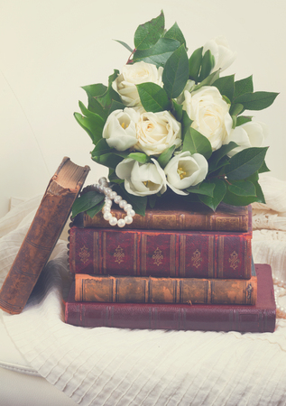 Old books with white flowers on romantic lace background, retro tonedの写真素材