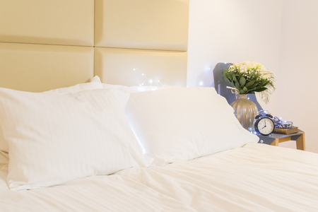 view of bed with white linen and pillows close up
