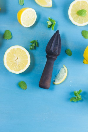 Fresh lemon citrus fruits with citrus reamer on blue bakground with copy spaceの写真素材