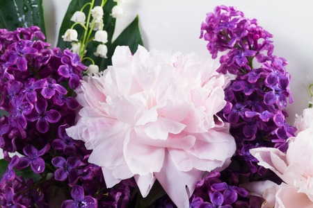 Floral scene of fresh flowers - lilac, peonies and lilly of the walley flowers close upの写真素材