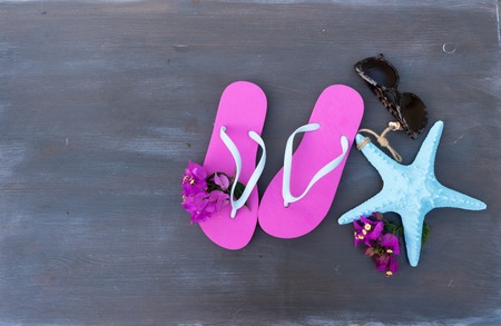 Summer beach fun - sandals with glasses and starfish on dark wooden backgroundの写真素材