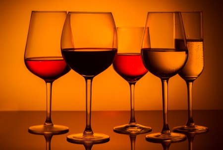 Set of wine glasses with red, white and rose wine on orange backgroundの写真素材
