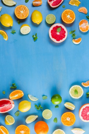 citrus food flat lay borders pattern on blue background - assorted citrus fruits with mint leavesの写真素材