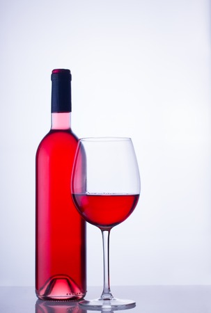 High glass with still rose wine and wine bottleの写真素材