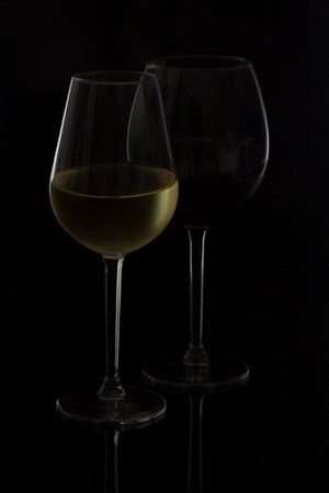 Wine glasses on black - two high glasses of red and white wineの写真素材