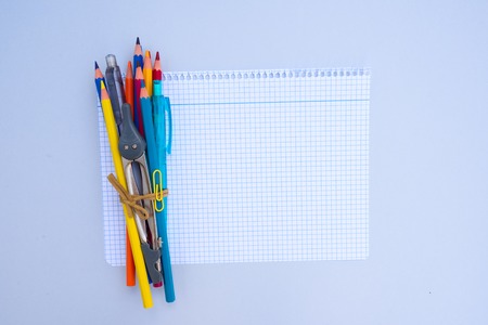 back to school concept - school supplies on ruled paper with copy space