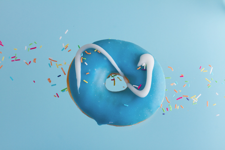 one flying sweet doughnut with sprincles on blueの写真素材