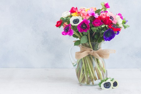 Fresh colorful Anemones flowers bouquet in vase on gray stone backgroundの写真素材
