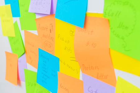 To do list - multicolored task notes close up on white wall