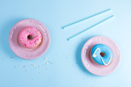 Two sweet doughnuts on blue background with copy spaceの写真素材