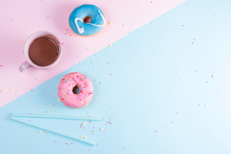 Two sweet doughnutswith cacao on blue and pink background with copy spaceの写真素材