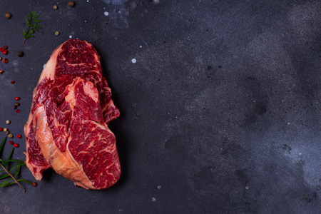 Raw beef steak on dark stone background with copy spaceの写真素材