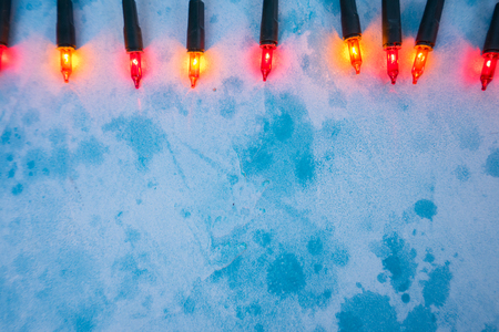 Christmas orange lights on blue background with copy space