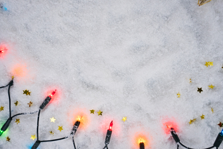 Christmas scene with lights and golden decoration in snowの写真素材