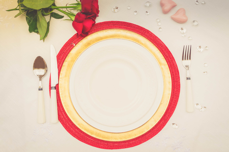 Served table for Valentines Dinner with fresh rose flowers, retro tonedの写真素材