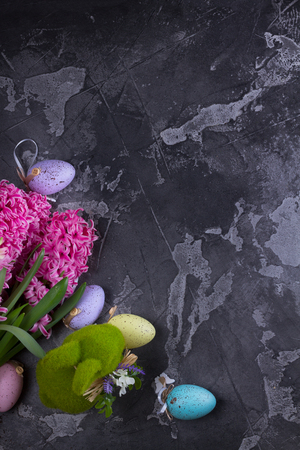 Easter scene with spring flowers, rabbit and colored eggsの写真素材