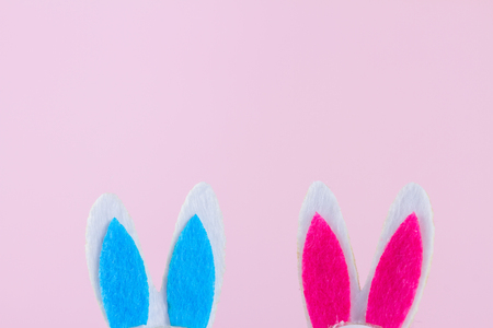 Pink and blue funny easter bunnies ears on pink background with copy spaceの写真素材