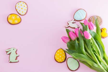 Eater handmade cookies with tulip flowers bouquet on pink backgroundの写真素材