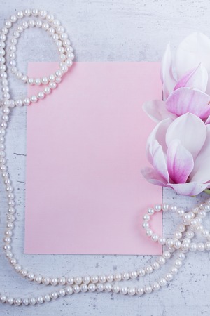 Magnolia flowers and jewellery flat lay composition with copy space on pink paper backgroundの写真素材