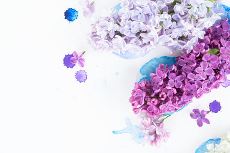 Fresh lilac flowers over white background with watercolor paint splashes, flat lay flower composition with copy spaceの写真素材