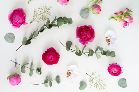 Flowers composition. Pattern made of eucaliptus leaves and ranunculus flowers on white background....
