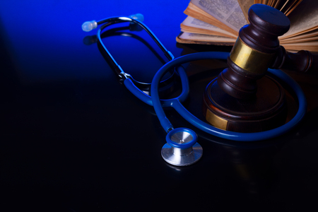 Wooden law gavel with stethoscope on blue with copy space - medical law and justice conceptの写真素材