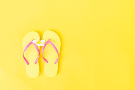 Summer flat lay scenery on yellow background with flip flops, copy spaceの写真素材