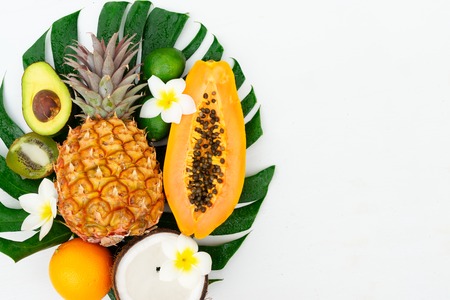 fresh fruits on green tropical leaf flat lay close up scene, summer diet backgroundの写真素材